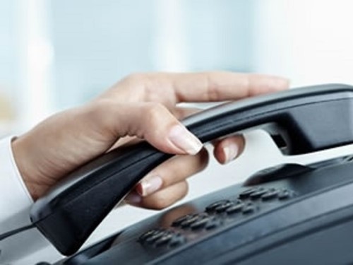 Hand holding office phone.