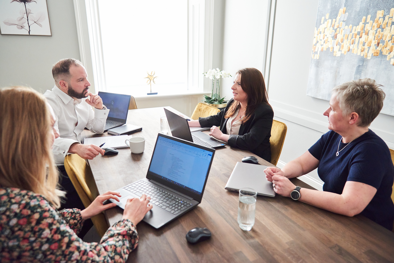 Cal partners team in conversation, sitting on at a desk. Pictured: Rachel Wright, Chris Lucarelli, Marianne Carey and Alison O'Neill.