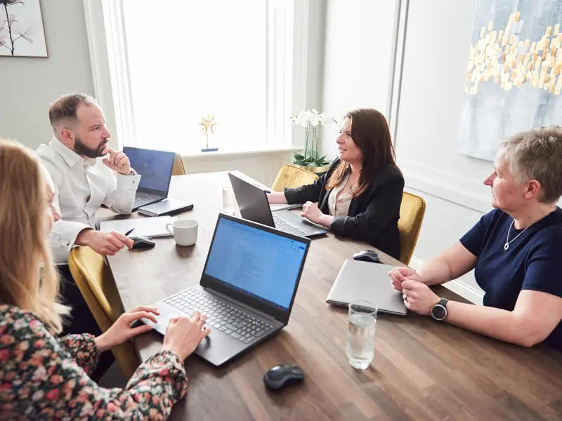 Cal partners team in conversation, sitting on at a desk. Pictured: Rachel Wright, Chris Lucarelli, Marianne Carey and Alison O'Neill.