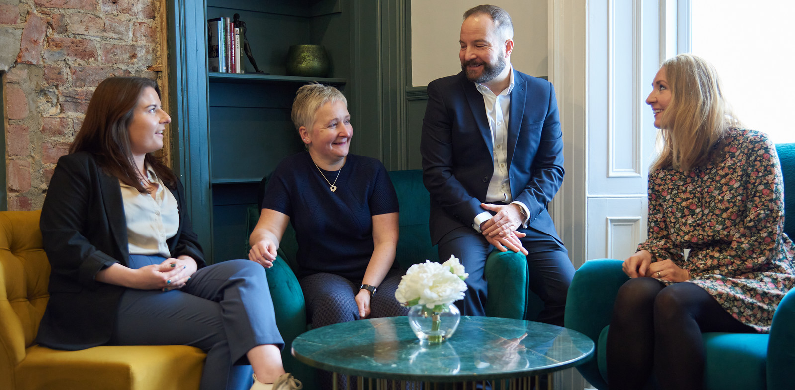 The Cal Partners team sitting on a sofa in conversation. 