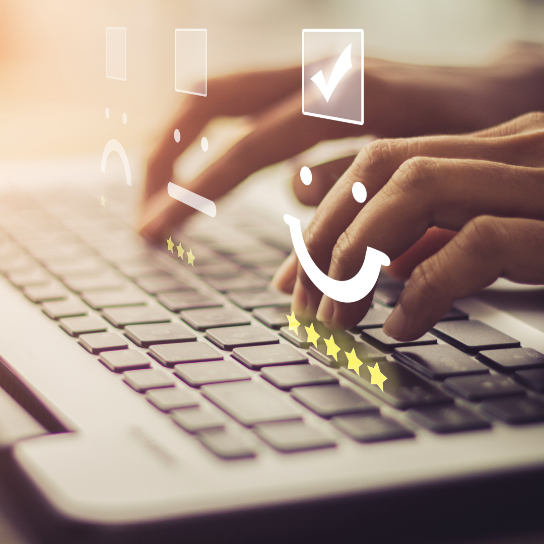 Hand typing on laptop. Above the hand is star ratings and 3 faces: Sad, neutral and happy.