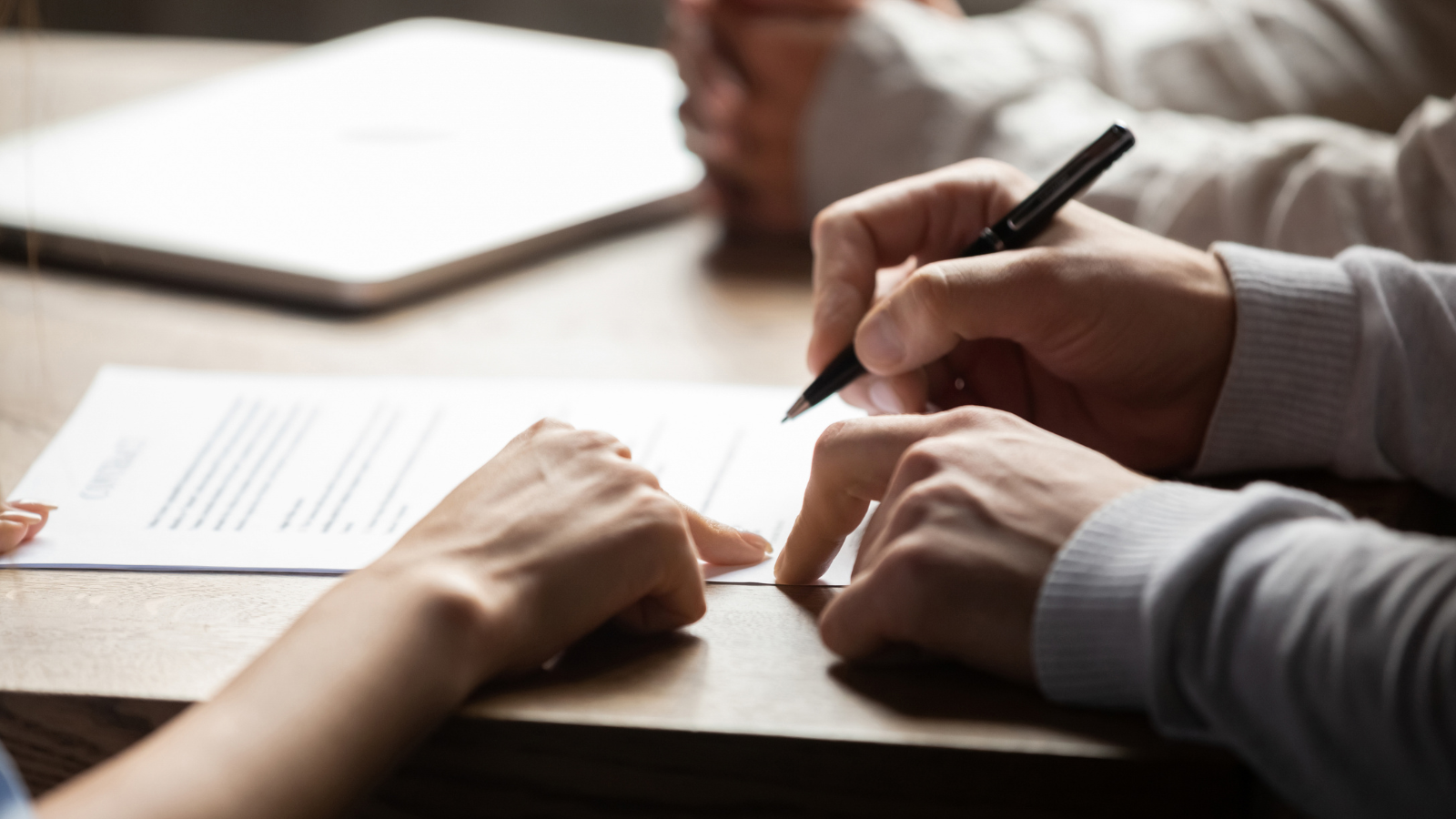 Hands pointing to contract.