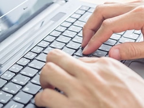Fingers typing on a keyboard.