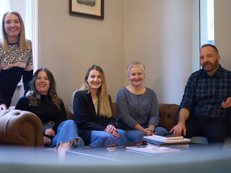 Team photo: Everyone is sitting on a brown leather sofa. Pictured left to right: Rachel Wright, Marianne Carey, Erin Cassidy, Alison O'Neill and Chris Lucarelli.