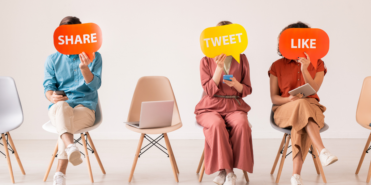 Woman sitting on chairs holding up signs 'Share' 'Tweet' 'Like'