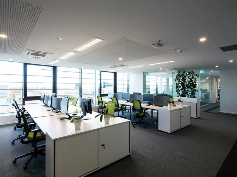 Office interior showing a bank of desks with computers and chairs.